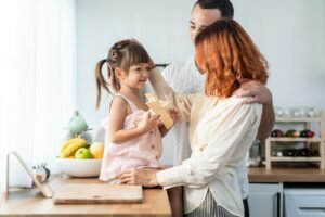 Asian attractive parents playing airplane toy with baby kid in kitchen.